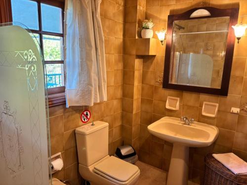 a bathroom with a toilet and a sink at Gate to the blue in Áyioi Apóstoloi