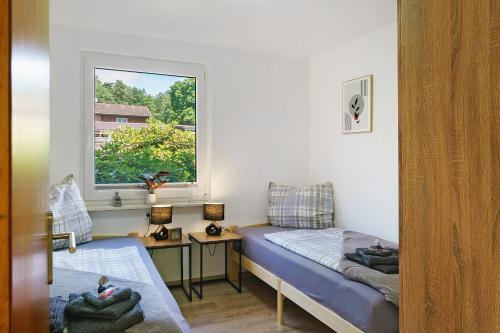 a small room with a bed and a window at Lärche in Sprakensehl