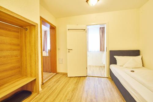 a small room with a bed and a door at Akzent Hotel Goldner Stern in Muggendorf
