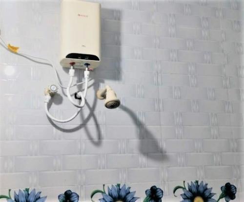 a wall with a hair dryer and a phone on a wall at Guru Room in Tiruvannāmalai