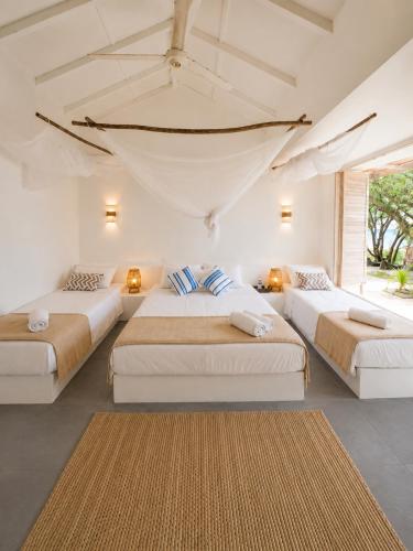 a room with three beds and a large window at Casa Rosario in Isla Grande