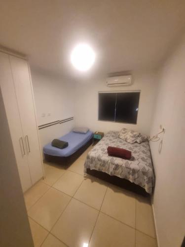 a small bedroom with a bed and a flat screen tv at Sobrado Mobiliado in Três Lagoas