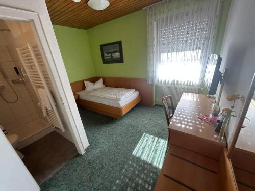 a small bedroom with a bed and a window at Hotel Deutsches Haus in Lampertheim