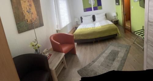 a bedroom with a bed and a chair in it at Hotel Deutsches Haus in Lampertheim