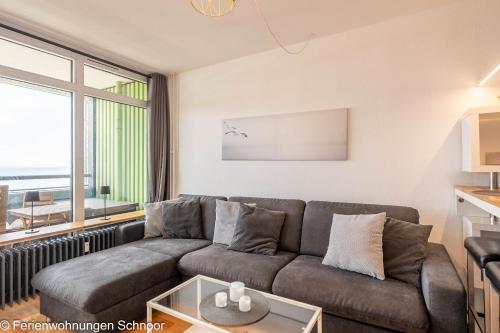 a living room with a couch and a large window at Waterkant in Schilksee