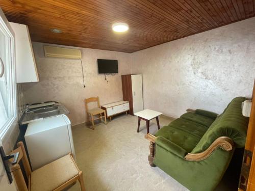 a living room with a green couch and a tv at Apartman Metovic in Bar