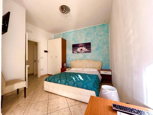 a bedroom with a bed with a blue wall at Residence Perla - Salve in Salve