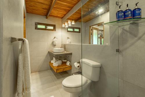 ein Badezimmer mit Toilette und Glasdusche in der Unterkunft Boutique Surf Hotel Rip Jack Inn in Playa Grande