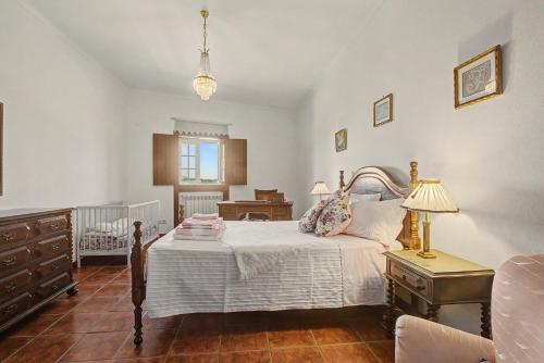 a bedroom with a bed with a dresser and a desk at Casa Da Redouça in Cedrim