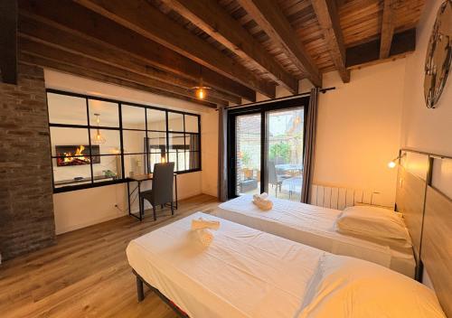 a room with two beds and a desk in it at Le Grainetier in Margny-lès-Compiègne
