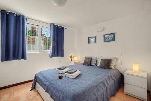 a bedroom with a blue bed with towels on it at Oasis Garden, Alegranza in Chayofa