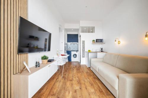 a living room with a couch and a tv at LE RIVA - Studio Hyper Centre - Parking - Wifi in Menton