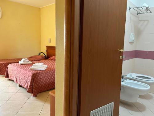 a room with two beds and a bathroom with a toilet at Residence Perla - Salve in Salve