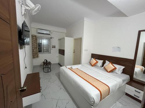 a bedroom with a large bed with orange pillows at S L N paradise in Chik Bānavar