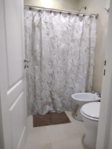 a bathroom with a white shower curtain and a toilet at Departamento Alquiler Temporal en Chascomús in Chascomús