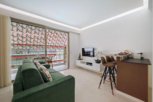 a living room with a green couch and a table at LAMAZONICO - Proche Centre - Terrasse Clim Plage in Menton