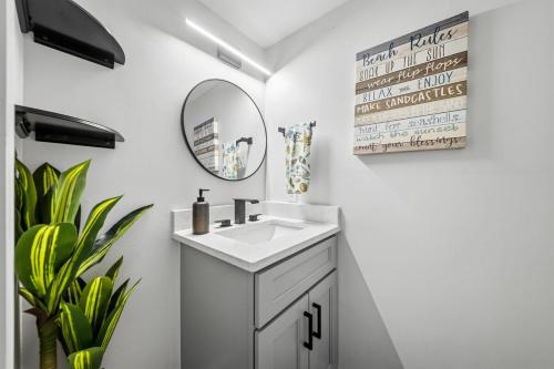 a white bathroom with a sink and a mirror at Carolina Beach Ocean Playground in Carolina Beach