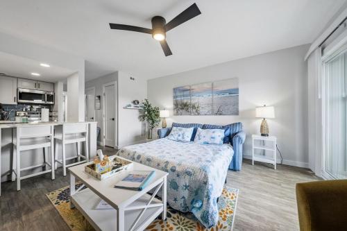 a living room with a bed and a kitchen at Carolina Beach Ocean Playground in Carolina Beach