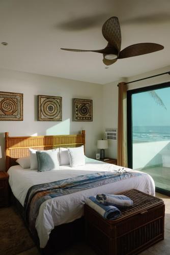 a bedroom with a large bed and a large window at The Cerritos Beach Inn in El Pescadero