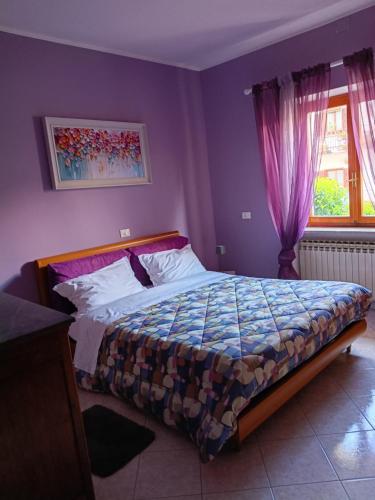 ein Schlafzimmer mit einem Bett in einem lila Zimmer in der Unterkunft Ca' Susy in Samone