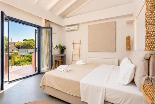 a bedroom with a large bed and a balcony at Villa Canova in Mesovoúnia