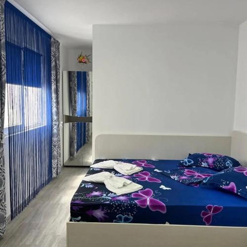 a bedroom with a blue bed with towels on it at Casa Inna Inna Corbu in Corbu
