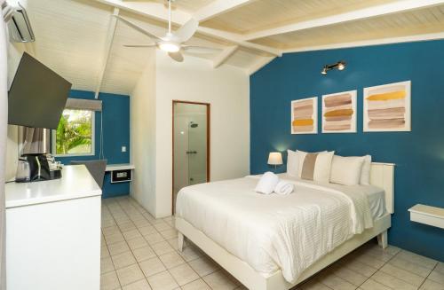 ein Schlafzimmer mit einem weißen Bett und einer blauen Wand in der Unterkunft Boutique Surf Hotel Rip Jack Inn in Playa Grande