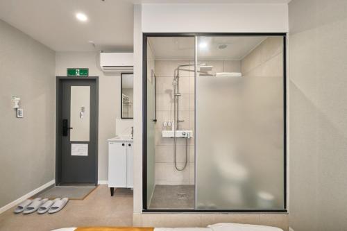 a bathroom with a shower and a glass door at Seoul Jongno Hostel in Seoul