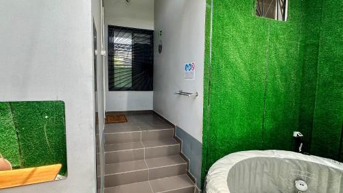 a bathroom with a green wall and a shower with stairs at Villa La Lagune in Mbour