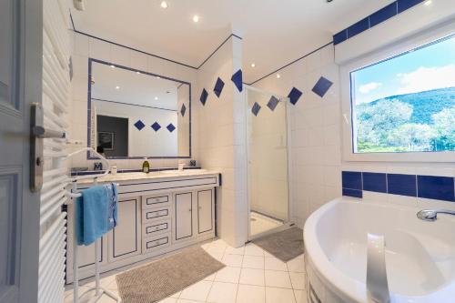 a bathroom with a tub and a sink and a mirror at Soleil de Provence in Nyons