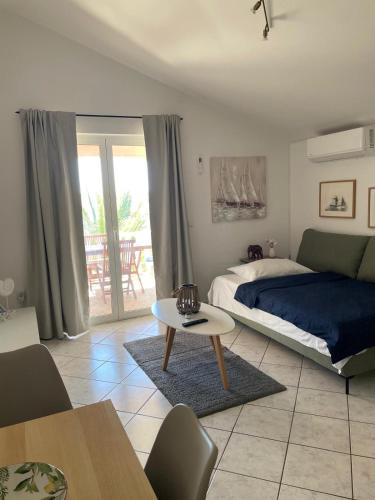 a bedroom with a bed and a table in it at Apartmani kod Lovrića in Vir