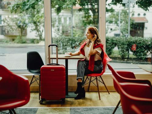 a woman sitting at a table with a cup of coffee at Ibis Győr in Győr