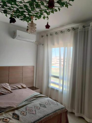 a bedroom with a bed and a window at Marina Blu Blumar Chalet in Ain Sokhna