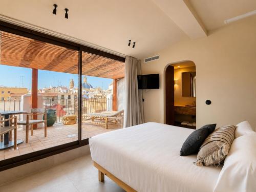 a bedroom with a large bed and a balcony at Cosy Rooms Bolsería in Valencia