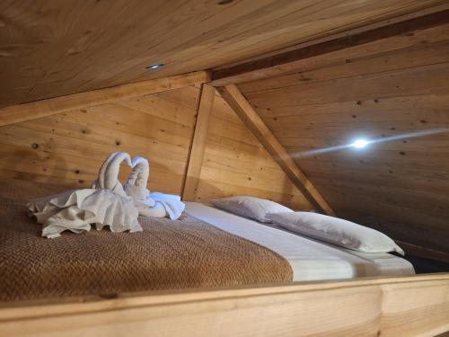 a bedroom with a bed with two swans towels at Cabana Plaiul Bucovinei in Câmpulung Moldovenesc