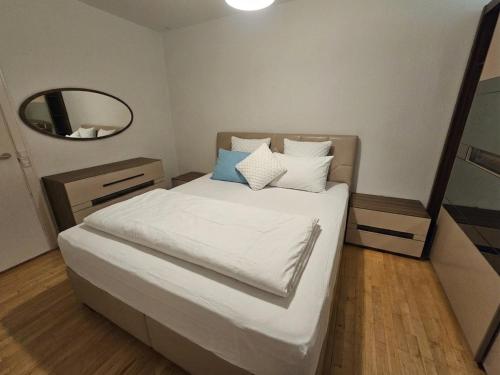 a small bedroom with a white bed with a mirror at Nice 3 Rooms apartment in Copenhagen