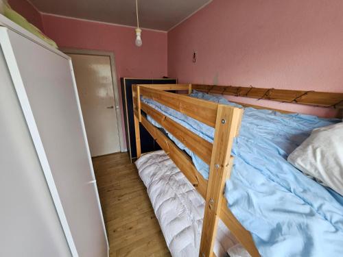 a bedroom with a wooden bunk bed with blue sheets at Nice 3 Rooms apartment in Copenhagen
