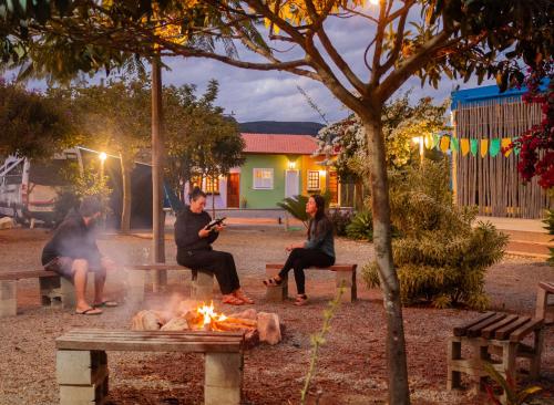 a group of people sitting around a fire in a park at Vila Caetité - Mucugê in Mucugê