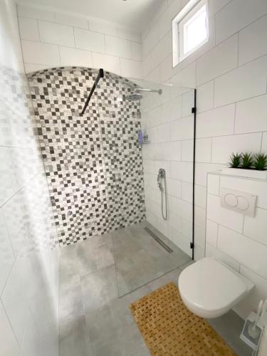 a white bathroom with a shower and a toilet at ETALON in the heart of Novi Sad in Novi Sad