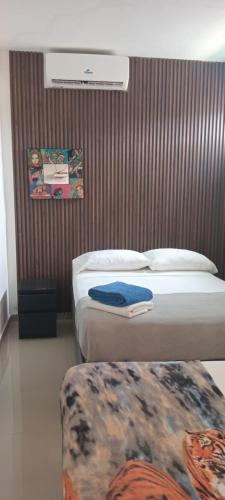 two beds in a hotel room with avertisement at Hostal Johnnier Macao Punta Cana in Punta Cana