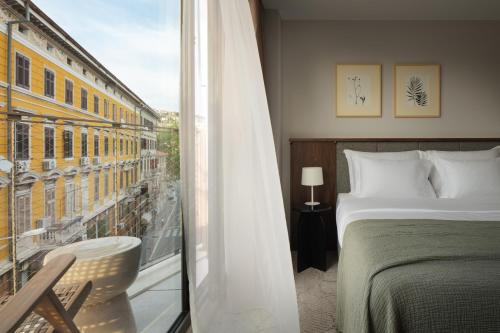 a hotel room with a bed and a window at Armerun Hotel Rijeka in Rijeka