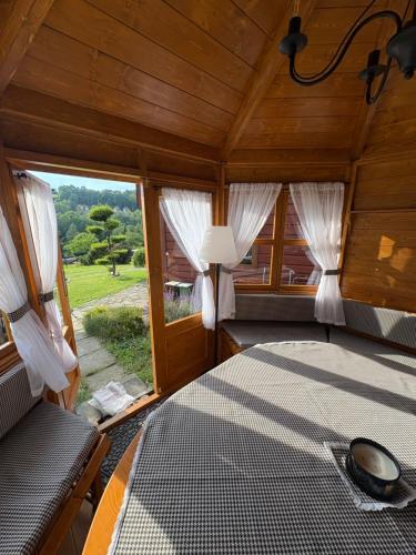 a bedroom with a bed and a large window at Domek pod Królowem in Ustroń