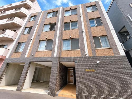 a tall brick building with a door in front of it at Rent菊水 -FIX HOME- in Sapporo