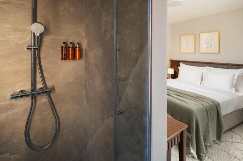a shower in a hotel room with a bed at Armerun Hotel Rijeka in Rijeka