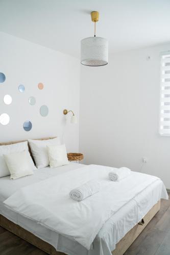 a white bedroom with a large white bed with white pillows at Vikendica Forest Mansion Surčin in Progar