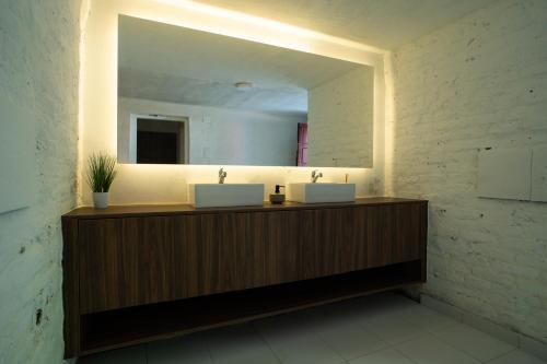 a bathroom with two sinks and a large mirror at Vikendica Forest Mansion Surčin in Progar