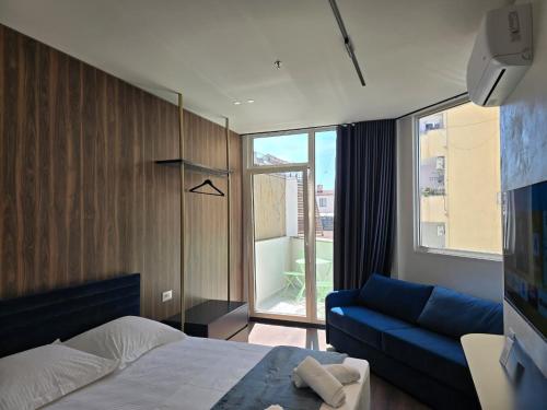 a bedroom with a bed and a blue couch at SOLs Center Rooms in Tirana