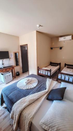a large bedroom with two beds and a tv at Pousada Central Parque in Penha