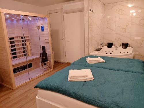 a bathroom with a bed and a tub and a shower at Apartment and Studios Jelovca & Wellness in Radovljica