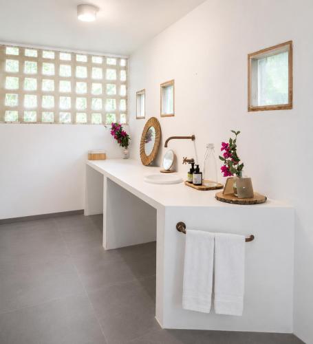 a white bathroom with a sink and a mirror at Casa Rosario in Isla Grande